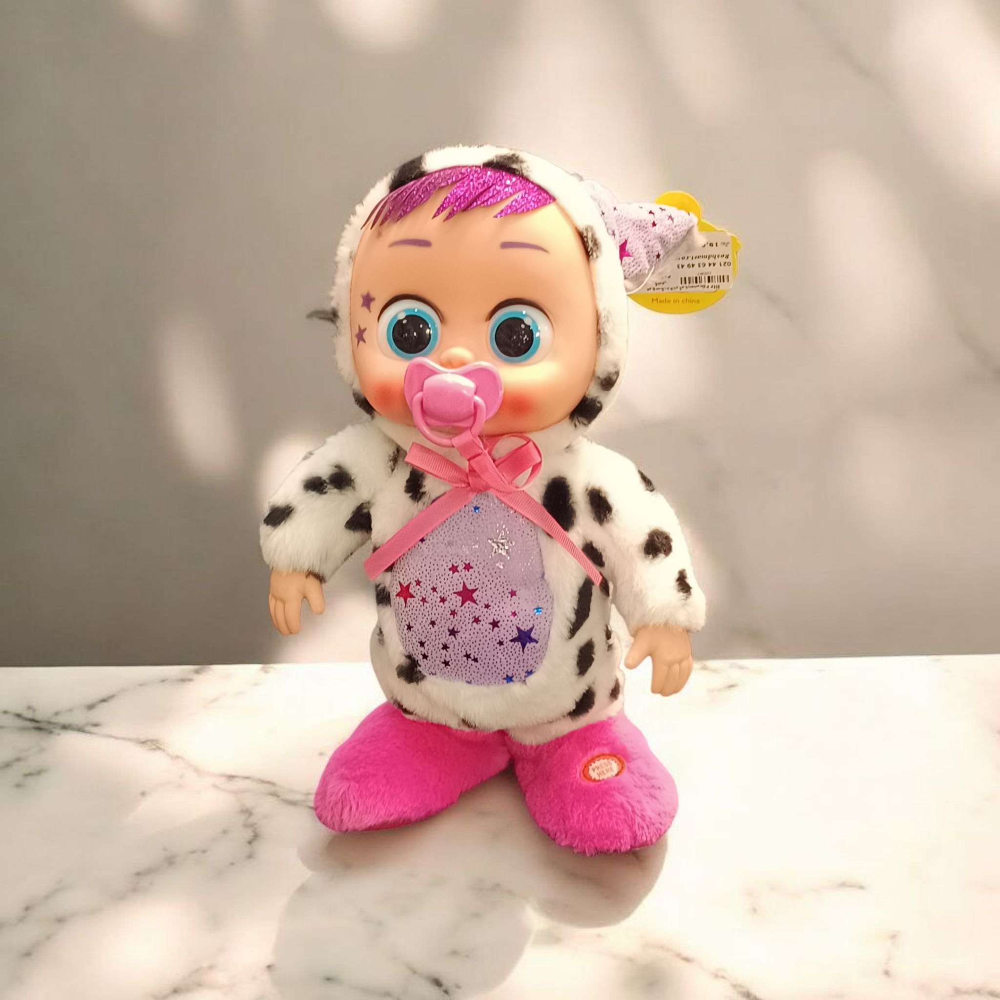 عروسک بی بی کرای با چشم‌های بزرگ آبی و شیشه‌ای و پستانک صورتی